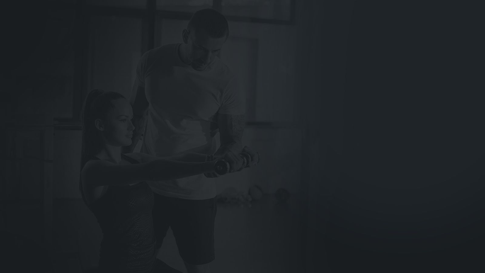 Profissional orientando uma aluna no exercício com halteres